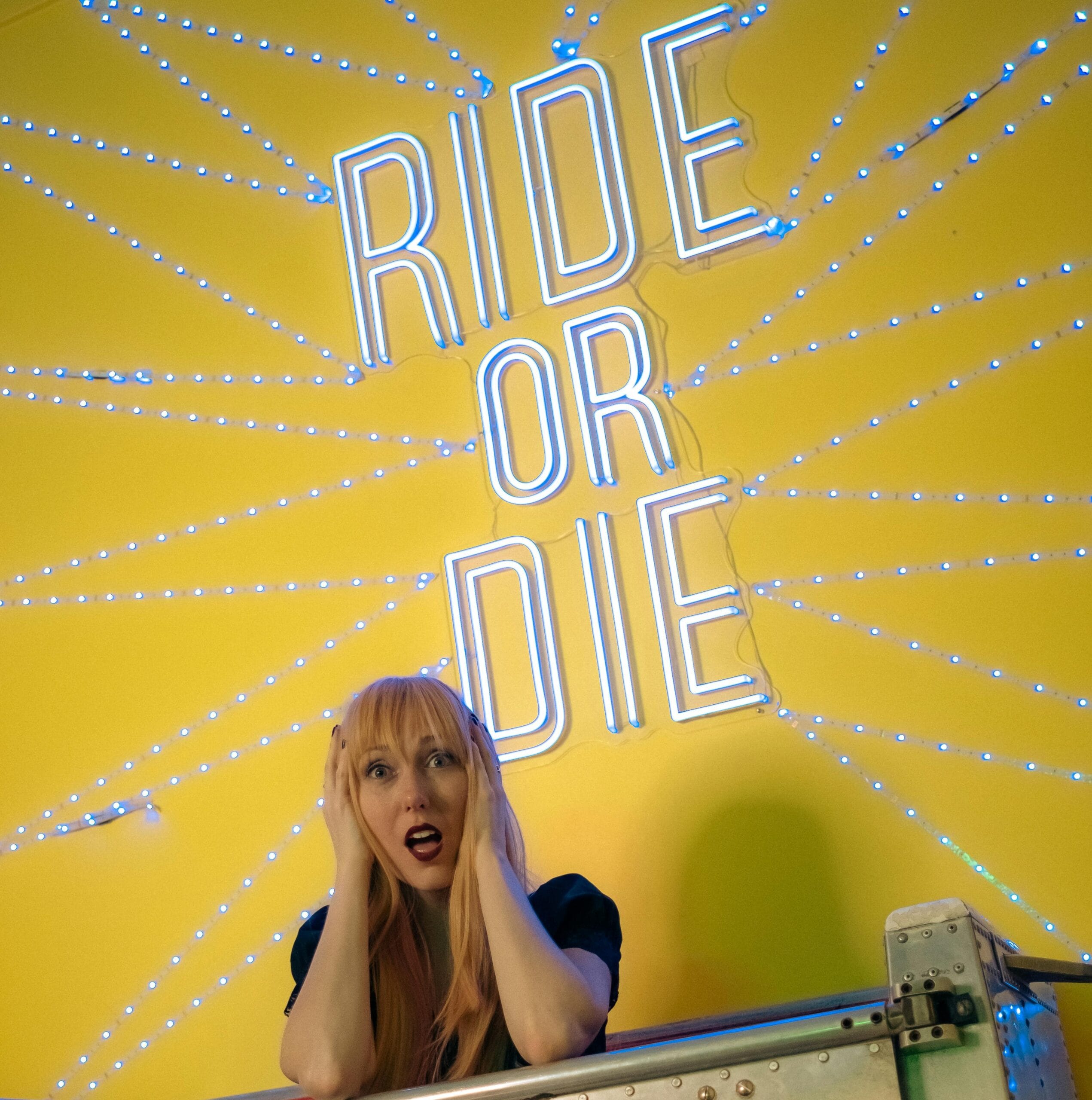 Large words "Ride or Die", woman underneath looking alarmed